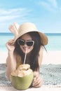 Female drinking coconut water on the beach