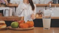 Portrait of pretty freelancer female working typing on laptop computer sitting at table smiling looking to screen in kitchen. Royalty Free Stock Photo