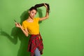 Portrait of pretty funky flirty girl cutting curls modern hairdo pout lips  over bright green color background Royalty Free Stock Photo