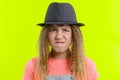 Portrait of a pretty funny teen girl with a pensive face, blonde girl with curly hair in hat with thoughtful expression, presses Royalty Free Stock Photo