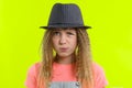 Portrait of a pretty funny teen girl with a pensive face, blonde girl with curly hair in hat with thoughtful expression, presses Royalty Free Stock Photo