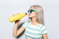 Portrait of pretty girl drinking water from thermo bottle on white background. Royalty Free Stock Photo