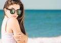 Portrait of a pretty girl with long hair in trendy sunglasses with palms reflection posing on the beach Royalty Free Stock Photo