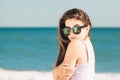 Portrait of a pretty girl with long hair in trendy sunglasses with palms reflection posing on the beach Royalty Free Stock Photo