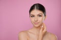 Portrait of pretty girl on pink background, space for text. Beautiful face with perfect smooth skin Royalty Free Stock Photo