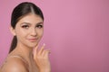 Portrait of pretty girl on pink background, space for text. Beautiful face with perfect smooth skin Royalty Free Stock Photo