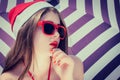 Portrait of a pretty girl in Santa Claus hat and red sunglasses Royalty Free Stock Photo