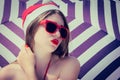 Portrait of a pretty girl in Santa Claus hat and red sunglasses Royalty Free Stock Photo