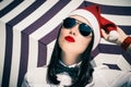 Portrait of a pretty girl in Santa Claus hat and sunglasses Royalty Free Stock Photo