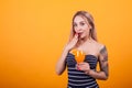 Portrait of pretty girl in sexy swimming suit holding a fresh cocktail over yellow background Royalty Free Stock Photo