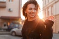 Portrait of a pretty happy beautiful young woman with a cute smile in a fashionable black T-shirt outdoors in the city Royalty Free Stock Photo