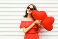 Portrait pretty happy smiling woman in red dress and sunglasses with air balloons heart shape over white Royalty Free Stock Photo