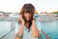 Portrait of a pretty happy woman with tattoos on a wooden pier by the sea. The concept of summer vacation Royalty Free Stock Photo