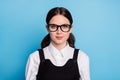 Portrait of pretty high school girl student look in camera wear uniform shirt overall isolated over blue color