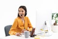 Portrait of pretty hotline assistant woman wearing microphone headset speaking with customer by phone in office Royalty Free Stock Photo