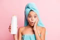 Portrait of pretty impressed girl wear teal towel show shower gel hand on cheek isolated on pastel pink background Royalty Free Stock Photo