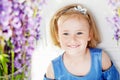 Portrait of pretty little emotion girl among violet flowers.Clouse up picture of beautiful smiling girl