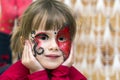 Portrait of pretty little girl with butterfly painting on her fa Royalty Free Stock Photo