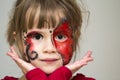 Portrait of pretty little girl with butterfly painting on her fa Royalty Free Stock Photo