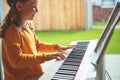 Portrait of pretty little girl having piano lesson at modern white e-piano Royalty Free Stock Photo