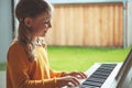 Portrait of pretty little girl having piano lesson at modern white e-piano Royalty Free Stock Photo