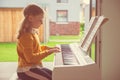 Portrait of pretty little girl having piano lesson at modern white e-piano Royalty Free Stock Photo