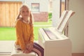 Portrait of pretty little girl having piano lesson at modern white e-piano Royalty Free Stock Photo