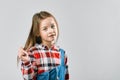 Portrait of a pretty little girl in jeans and a plaid shirt. studio fashion photography Royalty Free Stock Photo