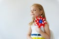 Portrait of pretty little girl with red windmill at summer day Royalty Free Stock Photo