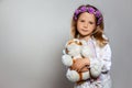 Portrait of pretty little girl  in white dress and purple wreath with plush tiger toy on gray isolated background. Royalty Free Stock Photo