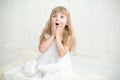 Portrait of pretty little girl in white dress , she is surprised and put her hands on cheeks. Royalty Free Stock Photo