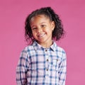 A portrait of a pretty little mixed race girl with curly hair posing against a pink copyspace background in a studio. A Royalty Free Stock Photo