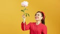 Portrait of a pretty lovely young girl casually dressed standing isolated over yellow background, holding peony flower Royalty Free Stock Photo