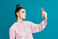 Portrait of pretty millennial hipster young woman taking selfie