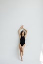 Portrait of pretty sensual natural girl in black swimsuit enjoying stretching Royalty Free Stock Photo