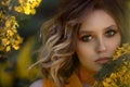 Portrait of a Pretty sensual woman on a background of a yellow blossom tree. Summer time, summer colors. Royalty Free Stock Photo