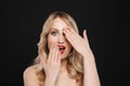 Shocked young blonde woman with bright makeup red lips posing isolated over black wall background Royalty Free Stock Photo