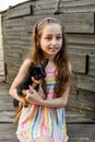 The child spending time with her pet. Little girl with chihuahua dog on the background of a wooden backdrop Royalty Free Stock Photo