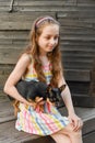 The child spending time with her pet. Little girl with chihuahua dog on the background of a wooden backdrop Royalty Free Stock Photo