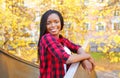 Portrait pretty smiling african woman wearing a red checkered shirt in sunny autumn Royalty Free Stock Photo