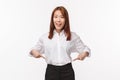 Portrait of pretty smiling asian woman in white shirt and black skirt invite check-out product, pointing fingers down Royalty Free Stock Photo