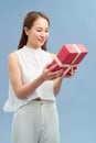 Portrait of a pretty smiling girl holding gift box and looking at camera isolated over blue backgroundPortrait of a pretty smiling Royalty Free Stock Photo