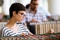 Portrait of a pretty smiling girl reading book in library Royalty Free Stock Photo