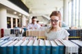 Portrait of a pretty smiling girl reading book in library Royalty Free Stock Photo