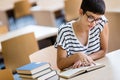 Portrait of a pretty smiling girl reading book in library Royalty Free Stock Photo