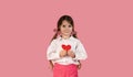 Portrait of pretty smiling preteen girl holding paper heart, happy looking at camera, posing isolated over pink Royalty Free Stock Photo