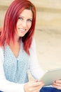 Portrait of a beautiful expressive redhead woman reading information on its touch pad Royalty Free Stock Photo