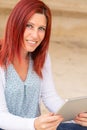 Portrait of a beautiful expressive redhead woman reading information on its touch pad Royalty Free Stock Photo