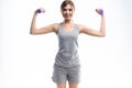 Portrait of pretty sporty girl holding weights dumbbells and make exercises on white background. Royalty Free Stock Photo