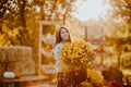 Portrait of teen girl posing with big yellow bouquet of autumn flowers at the open farm market place. Sunset Royalty Free Stock Photo